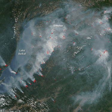 Satellite imagery that showing active wildfires (outlined in red) and smoke near the shoreline of Lake Baikal in southern Russia, July 27, 2017. The Russian environmental group Baikal Environmental Wave was deemed a "foreign agent" organization because it