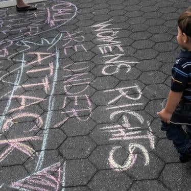 A boy looks at a writing on the ground during a protest in support of women's rights, in New York City, U.S. on October 7, 2017. 