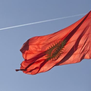 An airplane trace is seen behind a Kyrgyzstan national flag fluttering in a central square in Bishkek March 11, 2013.