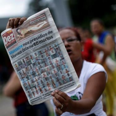 A relative of a prisoner holds a local newspaper, which shows a headline about a deadly prison riot, in front of Anisio Jobim prison in Manaus, Brazil, on January 3, 2017.