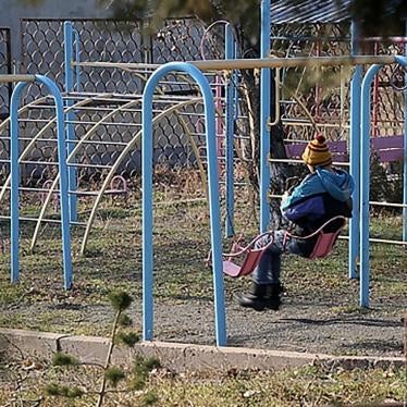 A boy sits on a swing in the courtyard of an orphanage for children with disabilities, Yerevan, Armenia.