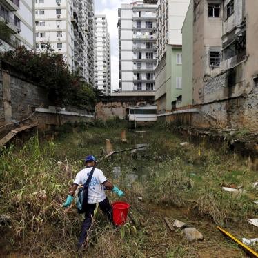 A health agent carries a bucket of guppy fish to place them in standing water to consume larva of Zika-transmitting mosquitoes in an empty lot of Rio de Janeiro's Tijuca neighborhood, Brazil, February 17, 2016. 