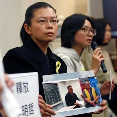 Li Ching-yu (C), a wife of Taiwanese human rights activist Li Ming-che, detained in China, attends a news conference in Taipei, Taiwan March 31, 2017.REUTERS/Tyrone Siu
