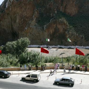 People stand near a border post on the Algerian side of the Morocco-Algeria border in the north east of Morocco July 31, 2011. © 2011 Youssef Boudlal /Reuters