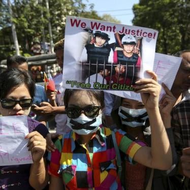 Protesters hold pictures of Zaw Lin and Win Zaw Htun as they protest in front of the Thai embassy in Rangoon on December 25, 2015. 