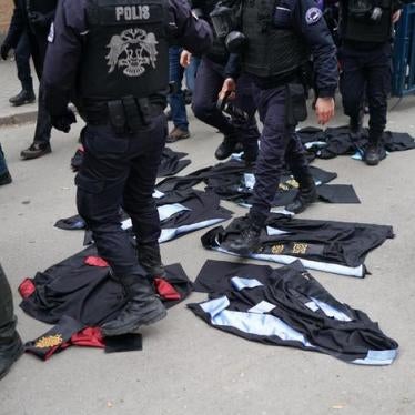 Turkish riot policemen walk over academic gowns laid down during a protest against the dismissal of academics from universities in the Cebeci campus of Ankara University