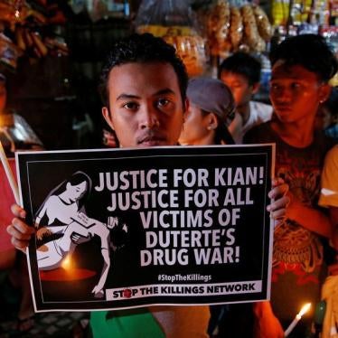Protesters and residents hold lighted candles and placards at the wake of Kian Loyd delos Santos, a 17-year-old high school student, who was among the people shot dead last week in an escalation of President Rodrigo Duterte's war on drugs in Caloocan city