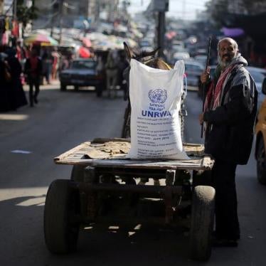 A Palestinian man stands next to a cart carrying a flour sack distributed by the United Nations Relief and Works Agency (UNRWA) in Khan Younis refugee camp in the southern Gaza Strip January 3, 2018. 