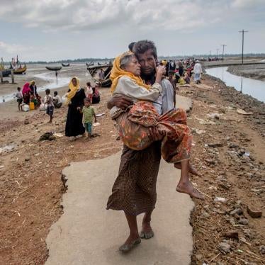 Abdul Kareem, a Rohingya Muslim, carries his mother, Alima Khatoon, to a refugee camp after crossing from Burma into Bangladesh on Sept. 16, 2017.