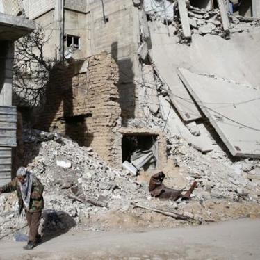 An elderly man walks near a damaged building in the besieged town of Douma in Eastern Ghouta, Syria.