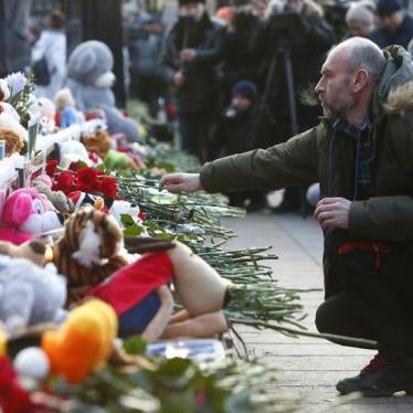A man places flowers at a makeshift memorial for the victims of the shopping mall fire in Kemerovo, at Manezhnaya square in central Moscow, Russia March 27, 2018.