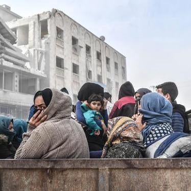 Residents sit in the back of a truck as they flee the city of Afrin in northern Syria on March 18, 2018, after Turkish forces and allied armed groups took control of the Kurdish-majority city. © 2018 Getty Images/Bulent Kilic/AFP