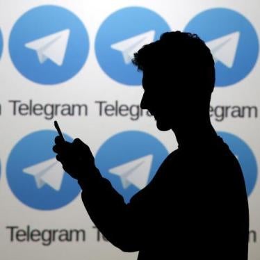 A man poses with a smartphone in front of a screen showing the Telegram logos in this picture illustration taken in Zenica, Bosnia and Herzegovina November 18, 2015.
