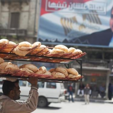 A man carries breads on his head along a busy street near a banner for Egypt's President Abdel Fattah al-Sisi from the campaign titled “Alashan Tabneeha” (So You Can Build It) after election results in Cairo, Egypt, April 3, 2018. REUTERS/Amr Abdallah Dal