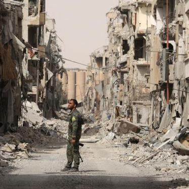 A fighter from Syrian Democratic Forces (SDF) stands next to debris of damaged buildings in Raqqa, Syria, September 25, 2017. © 2017 REUTERS