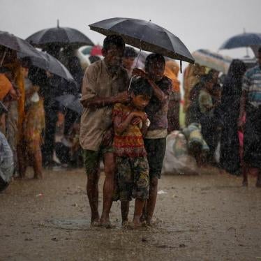 Rohingya refugees try to take shelter from torrential rain as they are held by the Border Guard Bangladesh (BGB) after illegally crossing the border, in Teknaf, Bangladesh, August 31, 2017.