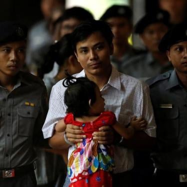 Detained and handcuffed Reuters journalist Kyaw Soe Oo carries his daughter Moe Thin Wai Zin while arriving for a court hearing in Yangon, Myanmar May 2, 2018. REUTERS/Ann Wang