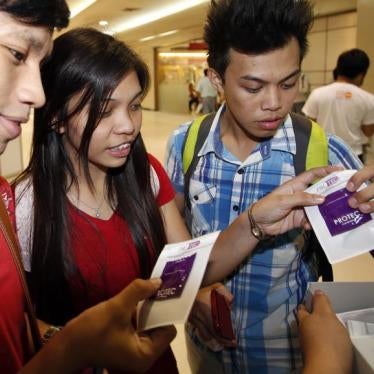 Students receive free condoms at an event organized by the United Nations Population Fund (UNFPA) in Metro Manila, July 11, 2014.
