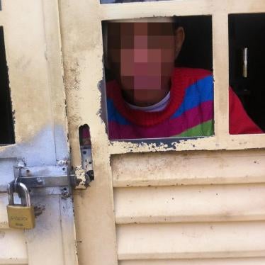 A man with an intellectual disability living in an institution for 51 people with disabilities in the outskirts of Brasília, Distrito Federal looking through a locked door. 