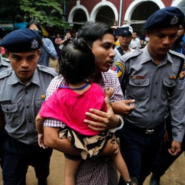 Kyaw Soe Oo carries his daughter while escorted by police outside a court in Yangon, Myanmar, June 18, 2018.