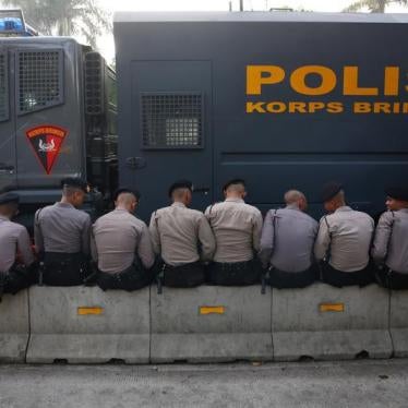 Police officers sit outside a court in Jakarta, Indonesia May 9, 2017.