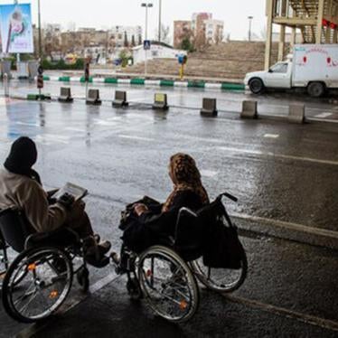 Two women who use wheelchairs attempting to cross a road in Tehran, the capital of Iran. 