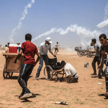 Tear gas fired by Israeli forces fall near Palestinian protesters on May 14 east of Jabalya in the Gaza Strip. 