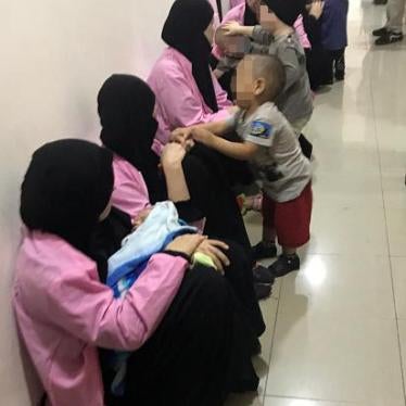 Russian women, sentenced to life in prison on grounds of joining ISIS, sit with children in a hallway of Baghdad's Central Criminal Court, April 29, 2018. © 2018 Ammar Karim/AFP/Getty Images