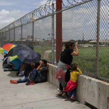 A Honduran mother and her 3-year-old daughter wait with fellow asylum seekers on the Mexican side of the Brownsville-Matamoros International Bridge after being denied entry by U.S. Customs and Border Protection officers near Brownsville, Texas, U.S., June