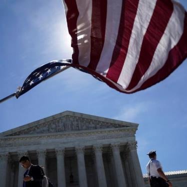 A man holds a flag outside the U.S. Supreme Court, as the Trump v. Hawaii case regarding travel restrictions in the U.S. remained pending, in Washington, U.S., June 25, 2018.