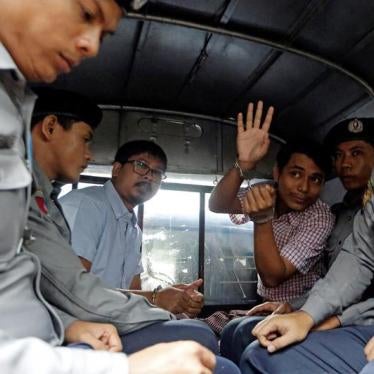 Detained Reuters journalist Wa Lone and Kyaw Soe Oo sit beside police officers as they leave Insein court in Yangon, Myanmar July 9, 2018. 