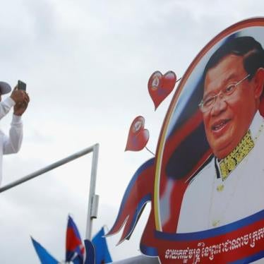 A supporter of the ruling Cambodian People's Party (CPP) uses a mobile phone to photograph a portrait of CPP president Hun Sen during an election campaign in Phnom Penh, Cambodia, July 7, 2018. REUTERS/Samrang Pring