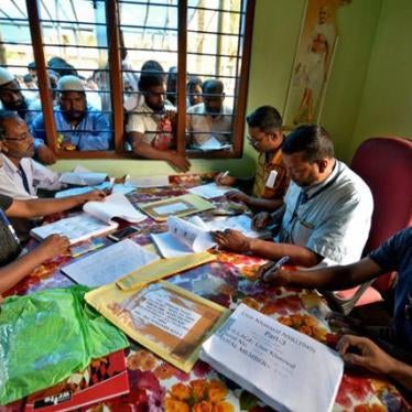 People wait to check their names on the draft list at the National Register of Citizens (NRC) centre at a village in Nagaon district.