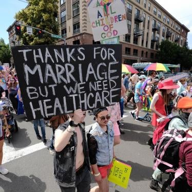 Participants at the Trans Pride March on June 16, 2018 in Portland, OR, display a placard calling for stronger healthcare protections. 