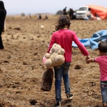 An Internally displaced girl from Daraa province carries a stuffed toy and holds the hand of child near the Israeli-occupied Golan Heights in Quneitra, Syria June 29, 2018. © 2018 Reuters/Alaa Al-Faqir