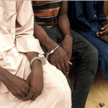 Police officers outline handcuffed suspected Boko Haram militants in Maiduguri, northest Nigeria, on July 18, 2018. 
