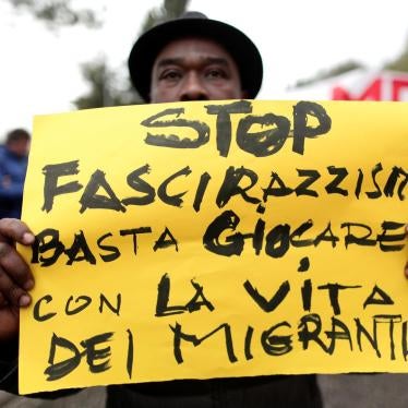 A demonstrator holds a banner reading "Stop fascism and racism: stop playing with migrants' life" during an anti-racism rally in Macerata, Italy, February 10, 2018.