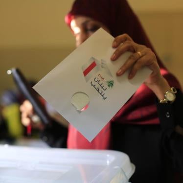 An election official shows a ballot with colors of political parties participating in the parliamentary election shortly after the polling stations closed in Beirut, Lebanon on May 6, 2018. © 2018 Bilal Hussein/AP Photo