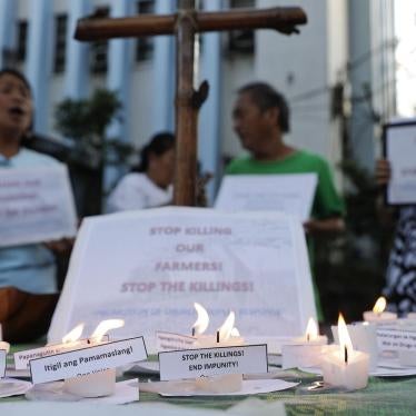 Activists shout slogans and offer prayers Monday, April 1, 2019, to protest the killings of what they claim were farmers in a central Philippine province. 