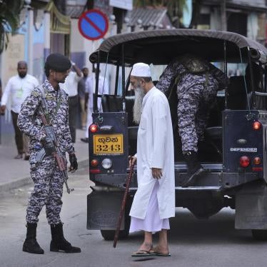 A Sri Lankan Muslim walks past patrolling army soldiers in Colombo, Sri Lanka, Friday, April 26, 2019.