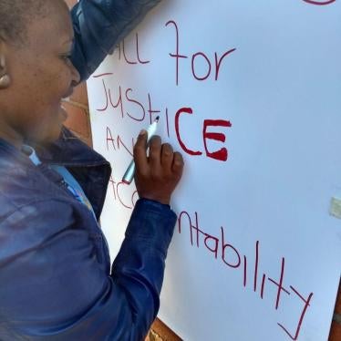 Phumzile Vilikhazi, who has an 18-year-old son with autism, writing “Today we appeal and call for justice and accountability” on a poster