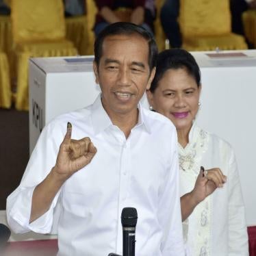 Indonesian President Joko "Jokowi" Widodo and his wife Iriana showing off their ink-marked fingers after casting ballots in the presidential election at a polling station in Jakarta on April 17, 2019. 