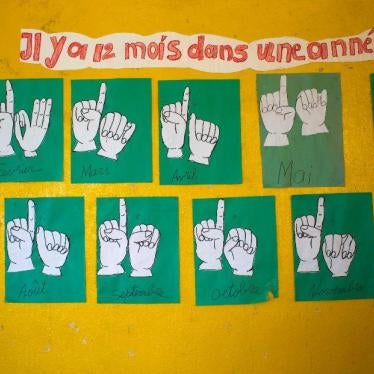 The names of the months in French and sign language are depicted inside a classroom for deaf students in Leveque