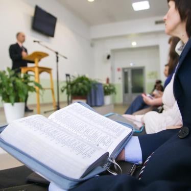 A woman holds a bible during a service
