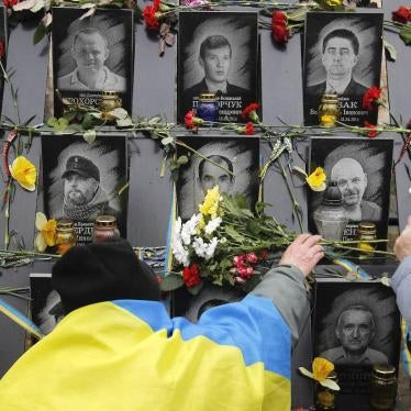 A man lays flowers to the memorial of dead Maidan activists during the anniversary in Kyiv