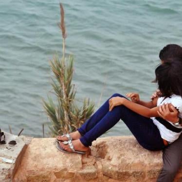 A couple sitting by the ocean in Rabat, Morocco. 
