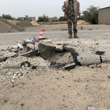 GNA checkpoint guard stands behind an expended cargo section of an RBK-250 PTAB-2.5M cluster bomb impacted into Alasfah Road near Tripoli International Airport following an attack on or around December 2, 2019, Tripoli outskirts, Libya, December 18, 2019.
