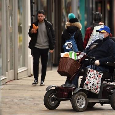 A man wears a protective face mask as he drives a mobility scooter in central Leeds on the morning of March 21, 2020.