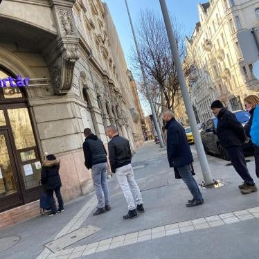 People in a line, using social distancing, in front of Budapest pharmacy” 