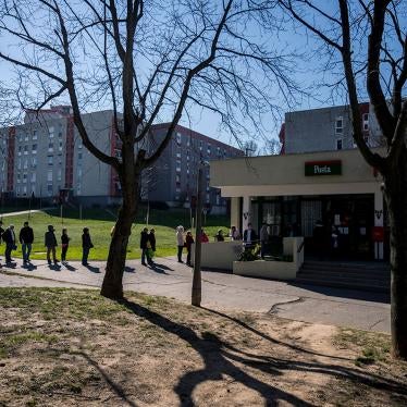 People keep their distance as they queue up in front of a post office in Pecs, Hungary, Monday, March 16, 2020.
